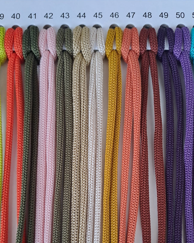 Polyester cord color sample for macramé and crochet, showing cords in shades of red, pink, burgundy, glitter green, bright green, olive, teal, dark green, beige, ivory, tan, blue, and yellow, labeled from 25 to 38.