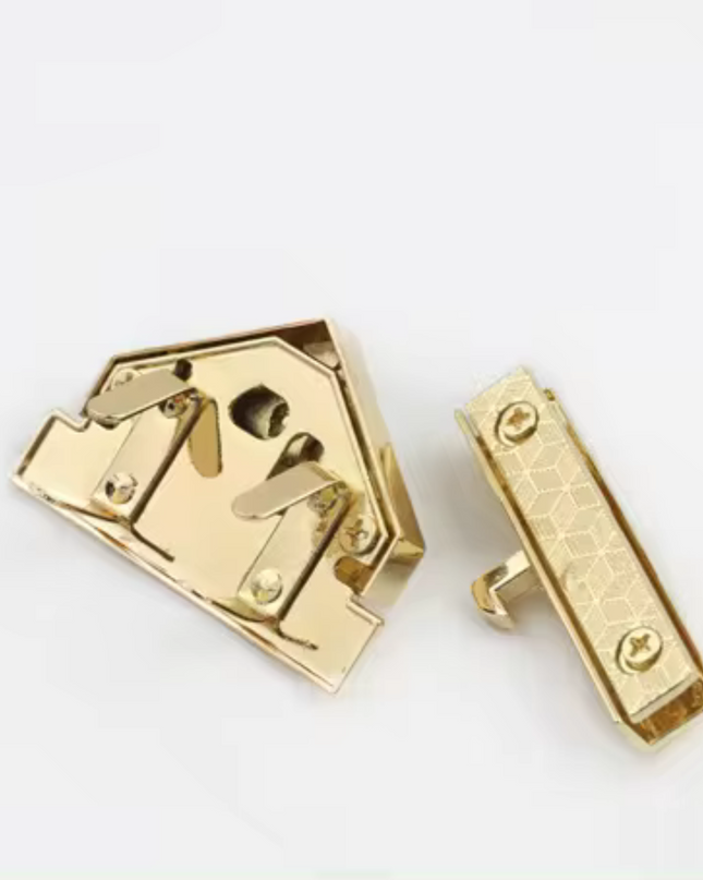 Back view of the gold triangle turn lock clasp showing screw holes and locking mechanism parts.